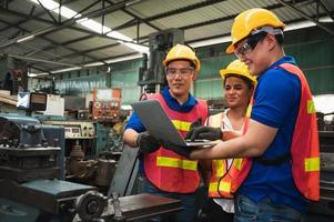 Das Industriearbeiterteam arbeitet an verschiedenen Projekten in einer großen Industriefabrik mit vielen Geräten.