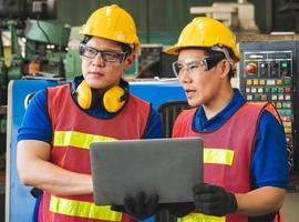 Asiatische Industriearbeiter diskutieren mit Laptops über Projektarbeit in großen Industrieanlagen. foto