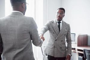 zwei gutaussehende, fröhliche afroamerikanische geschäftsleute im arbeitsbereich büro foto