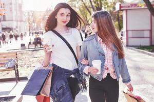 junge attraktive Mädchen mit Einkaufstüten und Kaffee in der Stadt