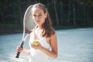 eine hübsche frau, die einen sportbekleidungstennisplatz auf dem platz trägt foto