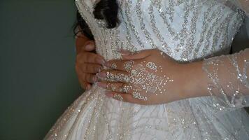 Braut im ein Hochzeit Kleid mit ein Muster auf ihr Hände. foto