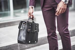 junger Geschäftsmann mit einer Aktentasche in der Nähe eines schönen Büros. Geschäftstreffen. foto