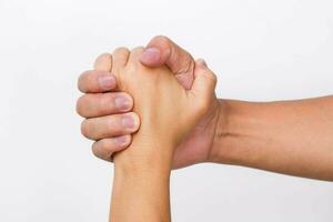 Hände von Männer und Frauen zittern Hände. zwei Menschen halten Hände auf Weiß Hintergrund. Das können bedeuten Portion, fürsorglich, beschützen, liebend, Pflege und Welt Frieden Konzept. foto