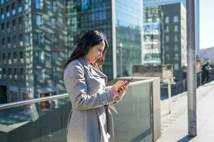 Geschäftsfrau Beratung Daten auf ihr Smartphone draußen das Büro foto