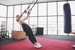 Frauen, die Liegestütze machen, trainieren Arme mit Trx-Fitnessgurten im Fitnessstudio-Konzept, trainieren gesunder Lebensstil Sport foto