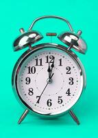 klassisch Jahrgang Alarm Uhr isoliert auf Grün Hintergrund. retro Alarm Uhr mit zwölf Uhr. foto