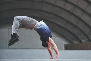 der Mann im Freien übt Parkour, extreme Akrobatik. foto