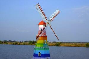 ein Regenbogen Windmühle auf das Kanal foto