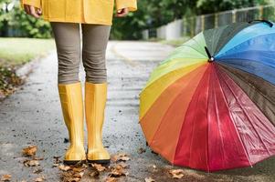 Frau Regenstiefel stehen bunter Regenschirm foto