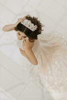 oben Sicht, schön Braut, mit ein Weiß Hochzeit Kleid und ein luxuriös Krone auf ihr Kopf. Vertikale Foto