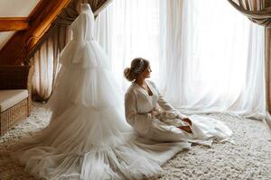 Porträt von ein schön Braut im ein Hotel in der Nähe von ein Hochzeit Kleid. Vorbereitung zum das Hochzeit Zeremonie. horizontal Foto. foto