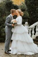 ein Hochzeit im ein luxuriös Standort. das Braut im ein Weiß Kleid mit ein lange Zug, das Bräutigam im ein klassisch grau Anzug. das zuerst Treffen von das Braut und Bräutigam. foto