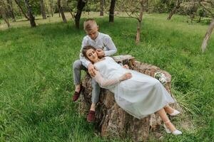 jung Paar im das Wald. Hochzeit gehen. das Braut Lügen auf das Runde von das Bräutigam foto