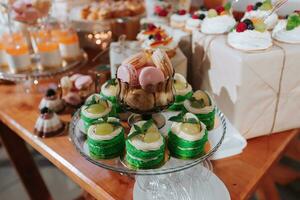 festlich Dessert Tabelle mit Süßigkeiten. Hochzeit Süßigkeiten Bar, verschiedene Kuchen, Pralinen auf steht. foto