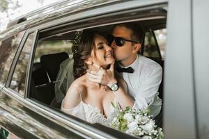 jung glücklich Braut und Bräutigam sind Jubel nach das Hochzeit Zeremonie im ihr Auto foto