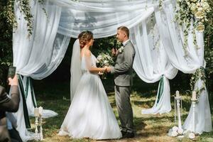 schön Hochzeit Paar beim ein Sommer- Hochzeit Zeremonie. Hochzeit Gelübde, Emotionen und Tränen foto