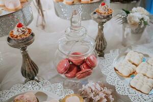 festlich Dessert Tabelle mit Süßigkeiten. Hochzeit Süßigkeiten Bar, verschiedene Kuchen, Pralinen auf steht. foto