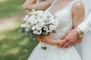 Hochzeit Strauß im das Hände von das Braut und Bräutigam. Betonung auf das Hochzeit Strauß, das Braut ist aus von Fokus foto