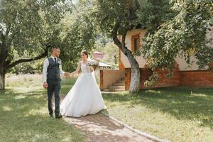 das Braut und Bräutigam gehen nach das Hochzeit Zeremonie. jung Paar Gehen im das Garten. Foto im Natur, Wald, im Natur.