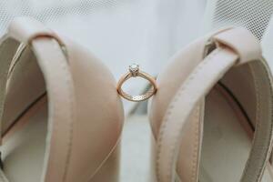 elegant Schuhe. ein Diamant Engagement Ring sitzt zwischen ein Paar von klassisch Braut- Schuhe. Mode. Stil. Hochzeit Foto