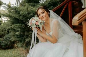 schön Braut im ein modisch Hochzeit Kleid auf ein natürlich Hintergrund im das Park. ein atemberaubend jung Braut ist unglaublich glücklich. glücklich Mädchen auf ihr Hochzeit Tag foto