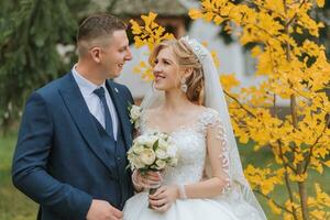 Bräutigam und Braut im Herbst Wald, Hochzeit Zeremonie, Seite Sicht. Bräutigam und Braut auf das Hintergrund von vergilbt Herbst Blätter. das Foto war genommen durch das Vergilbung Blätter von das Bäume