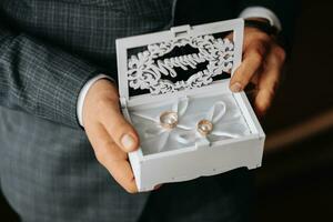 golden Hochzeit Ringe im ein Geschenk Kasten, im das Hände von das Bräutigam, Nahansicht foto