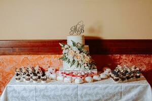 ein Süss Tabelle beim ein Hochzeit. Hochzeit Kuchen. Tabelle mit Kuchen und Süßigkeiten beim das Festival. Geburtstag Süßigkeiten foto