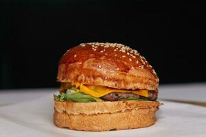 Nahansicht von ein Hamburger auf ein Weiß Teller mit schwarz Hintergrund foto