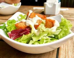 Salat mit gebraten Hähnchen und Mayonnaise Dressing auf hölzern Tabelle foto