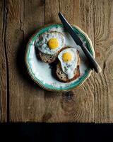 gebraten Eier auf Toast zum Frühstück. dunkel rustikal Stil. foto