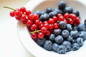 Blaubeeren und rot Johannisbeeren im ein Schüssel, Nahansicht foto