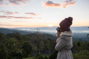 Frau wacht morgens auf, entspannt sich auf dem Berg foto