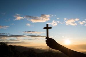 Silhouette der Hand halten das Kreuz Gottes foto