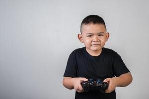 glücklicher Junge spielt Spielcomputer mit einem Controller im Studiofoto foto