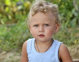 schönes Baby mit Kindergesicht posiert Fotograf für Farbfoto