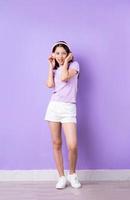 Bild des jungen asiatischen Mädchens Ganzkörper auf lila Hintergrund foto