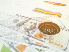 Geschäftsberichtsdiagramm und Finanzdiagrammanalyse mit Dollargeld und Kompass auf dem Tisch foto