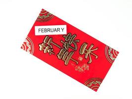 roter Umschlag isoliert auf weißem Hintergrund mit Februar für Geschenk Chinesisches Neujahr. chinesischer Text auf Umschlag bedeutet frohes chinesisches neues Jahr foto