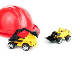 roter Schutzhelm mit mechanischem Bagger und Bulldozer-Spielzeug, Ingenieurbaukonzept foto