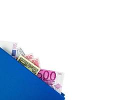 blaues Buch mit verschachtelten internationalen Banknoten, isoliert auf weißem Hintergrund. Geldvorrat Konzept, Geschäftsideen, Beschneidungspfad foto
