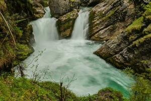 eilen doppelt Wasserfall Über Felsen und Pflanzen und ein Becken genannt strumboding Wasserfall foto