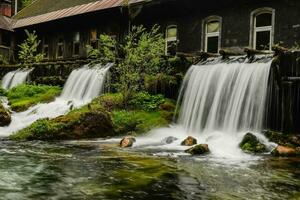 tolle Wasserfälle in der Nähe von ein alt verlassen Fabrik Detail foto