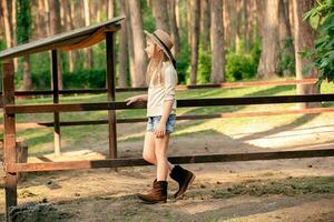 lächelnd preteen Mädchen Gehen in der Nähe von Tier Stall im Land Nachlass im Wald foto