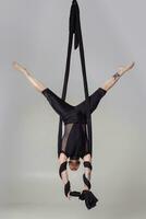 sportlich Mann im ein schwarz Sport passen ist durchführen ein akrobatisch Elemente im ein Studio. foto