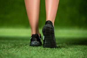 seine Füße schön Frau im das Schuhe sind auf ein Gras. schließen oben foto