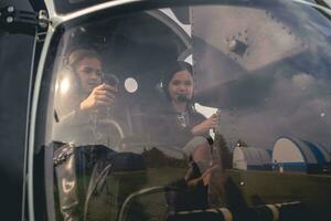 Tween Mädchen im Headsets Sitzung auf Pilot Sitze im Hubschrauber foto