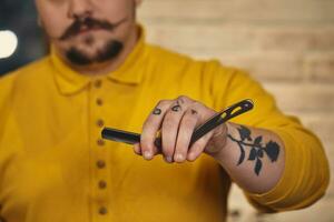 stilvoll Barbier Mann mit Friseur Werkzeuge im seine Hände bereiten zum Arbeit foto