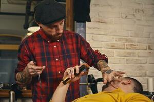 Klient während Bart Rasieren im Barbier Geschäft foto